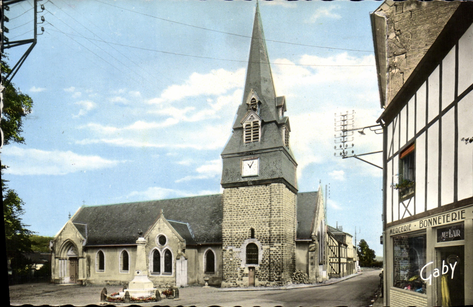 Église de Fervaques — vue de la place avec monument et boutique — Gaby
