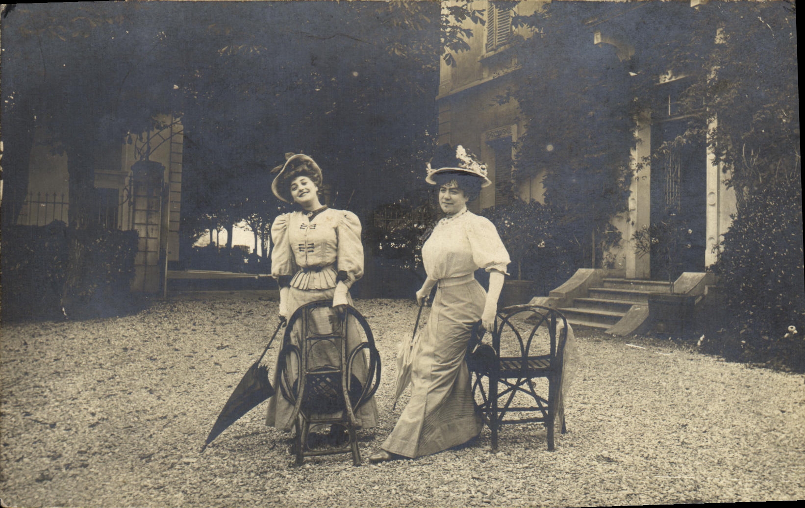 Deux dames en tenue d'époque — jardin d'une demeure — éditeur non visible
