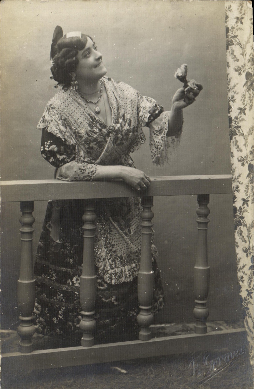 Femme en robe à motifs — pose sur balcon — J. Gommer