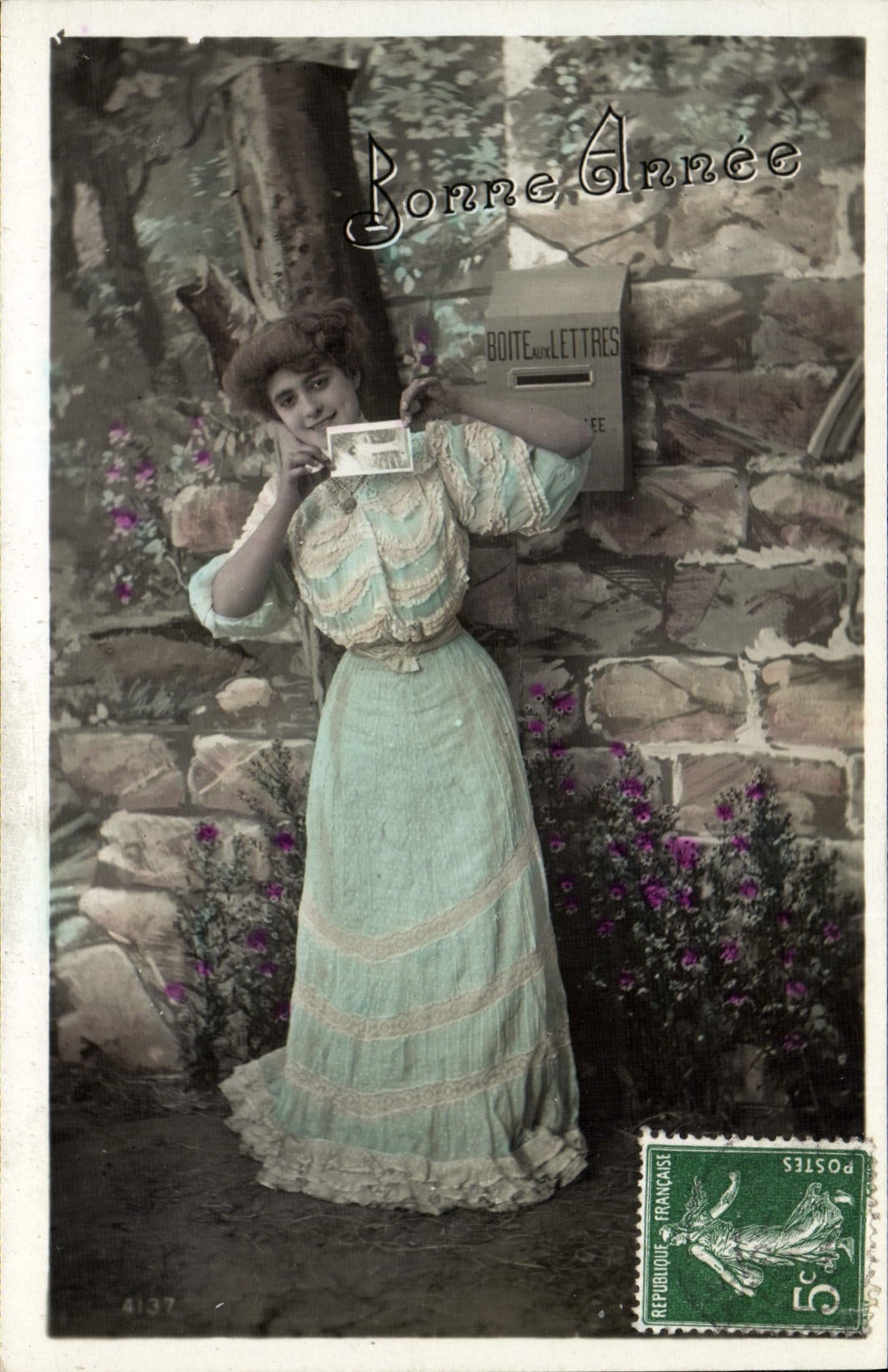Jeune femme en robe bleu pâle — tenant une carte postale — éditeur '4137'