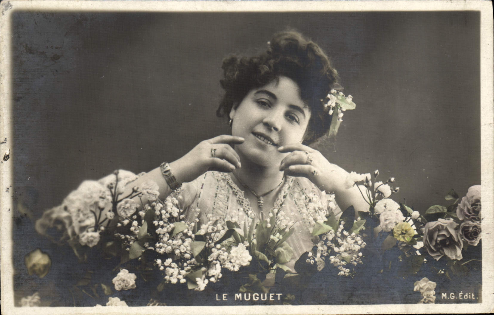 Le Muguet — femme souriante entourée de fleurs — M.G. Édit.