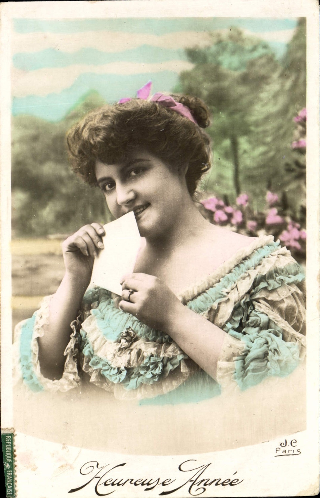 Jeune femme souriante tenant une carte — Heureuse Année — J.C. Paris