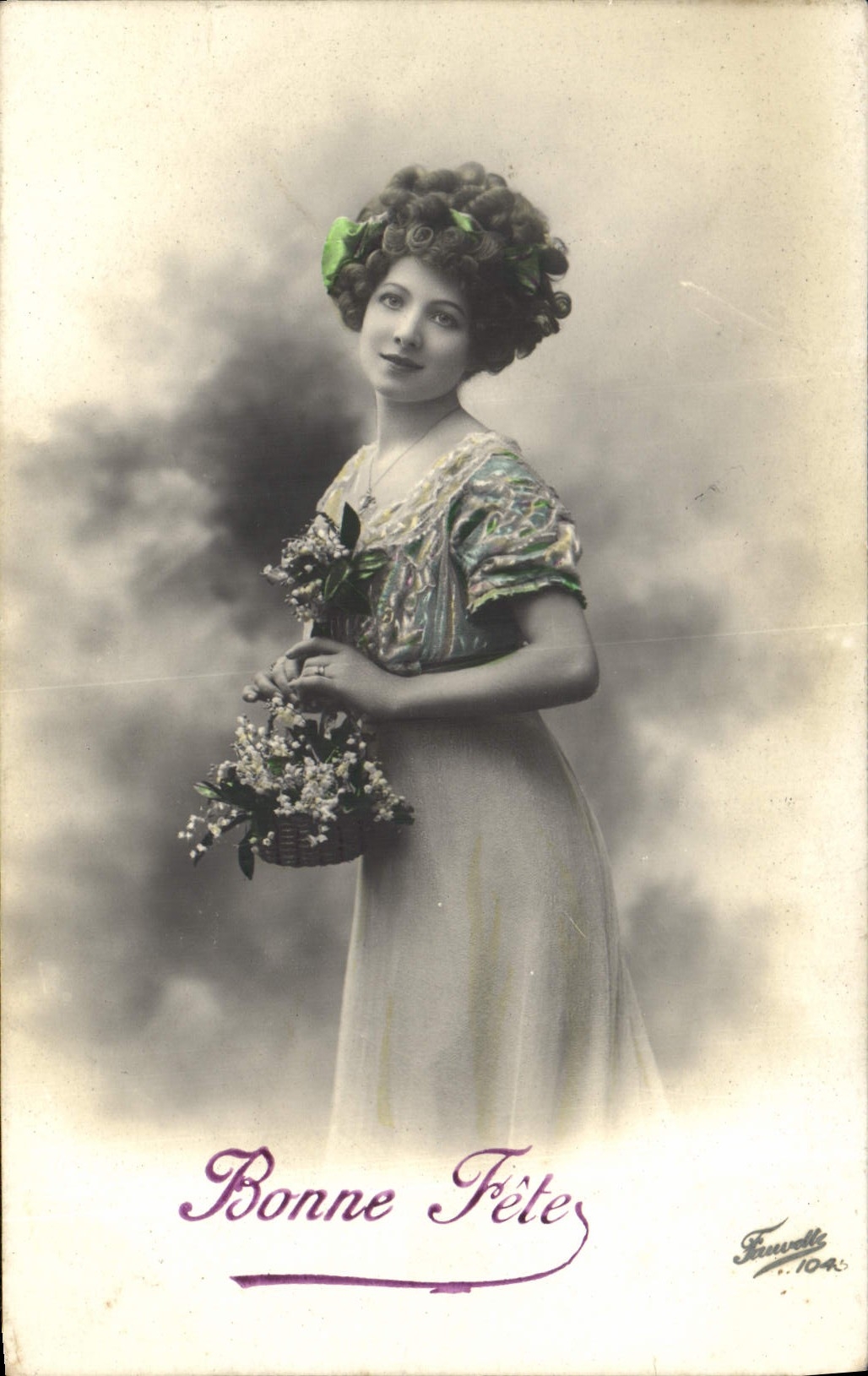 Femme en robe à motifs — avec couronne de fleurs et panier — éditée par Fauvelli n°104