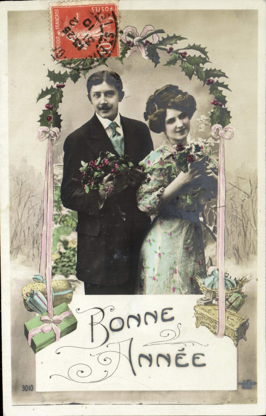 Couple en tenue de Noël — décor de houx et de cadeaux — éditeur H.T. n° 3010