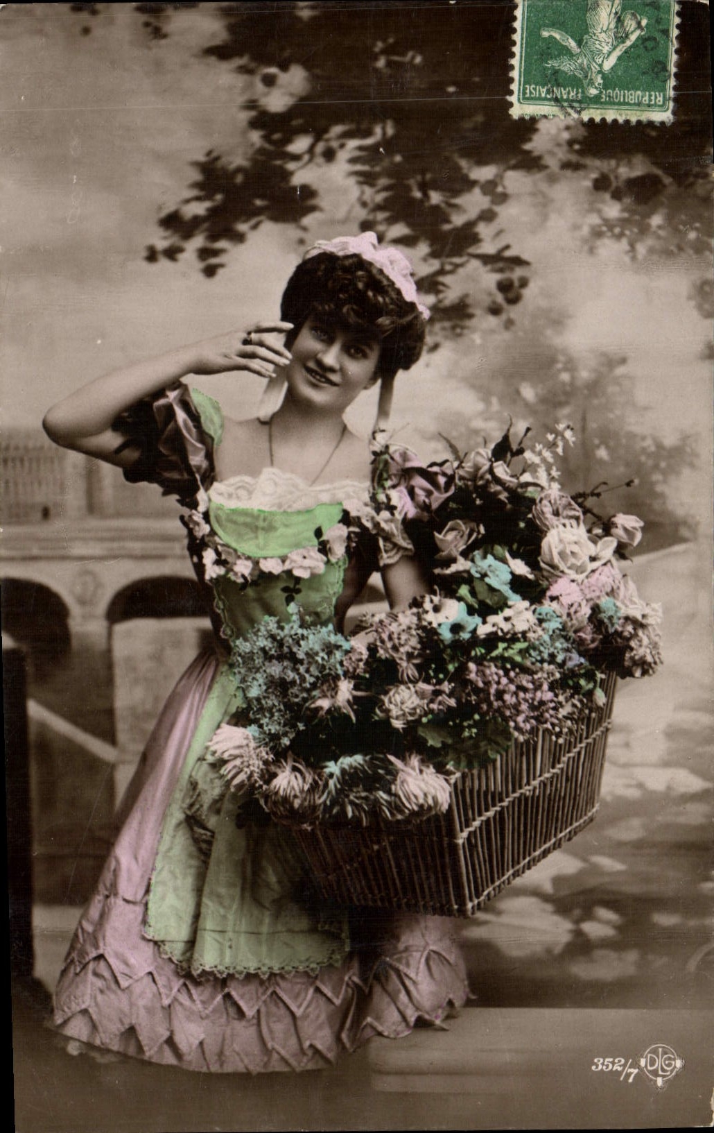 Joven mujer vestida con un vestido colorido sosteniendo un cesto de flores — editor D.G. n°352/7