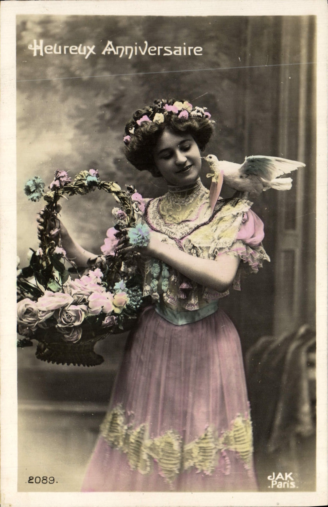 Femme en robe rose tenant un panier de fleurs — oiseau blanc sur l'épaule — JAK Paris n° 2089