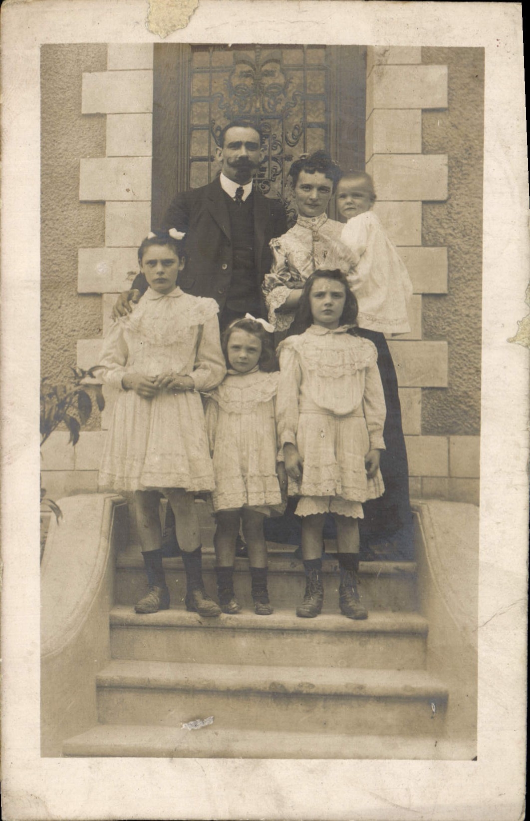 Famille devant une maison — éditeur non visible — n° de série non visible