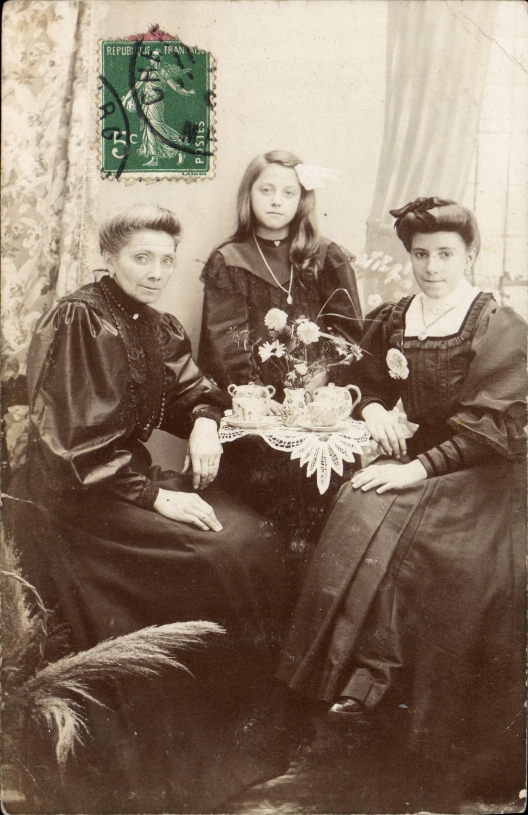 Tres mujeres en traje de la época — escena del té — editor desconocido, n. serie 87