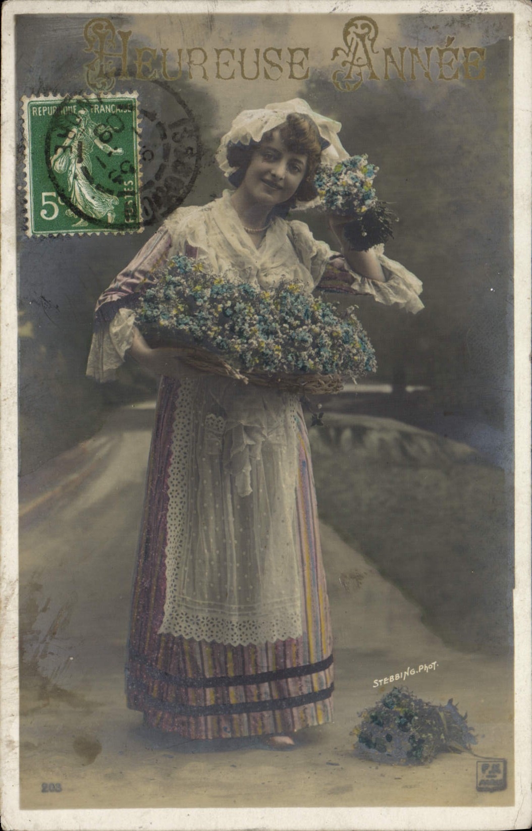 Frau in einem farbigen Kleid mit einem Blumenkorb — Frohes Neues Jahr — Stebbing-Phot.