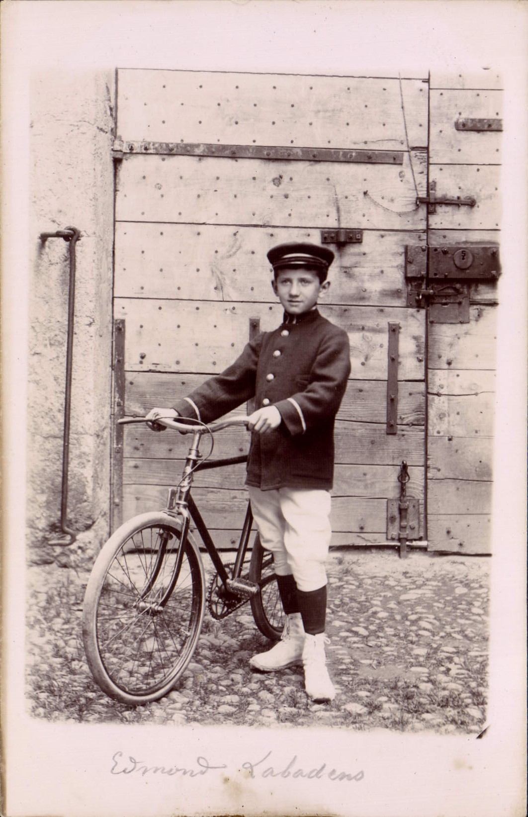 Edmond Kabadens — jeune garçon en uniforme avec vélo — Carte postale anonyme