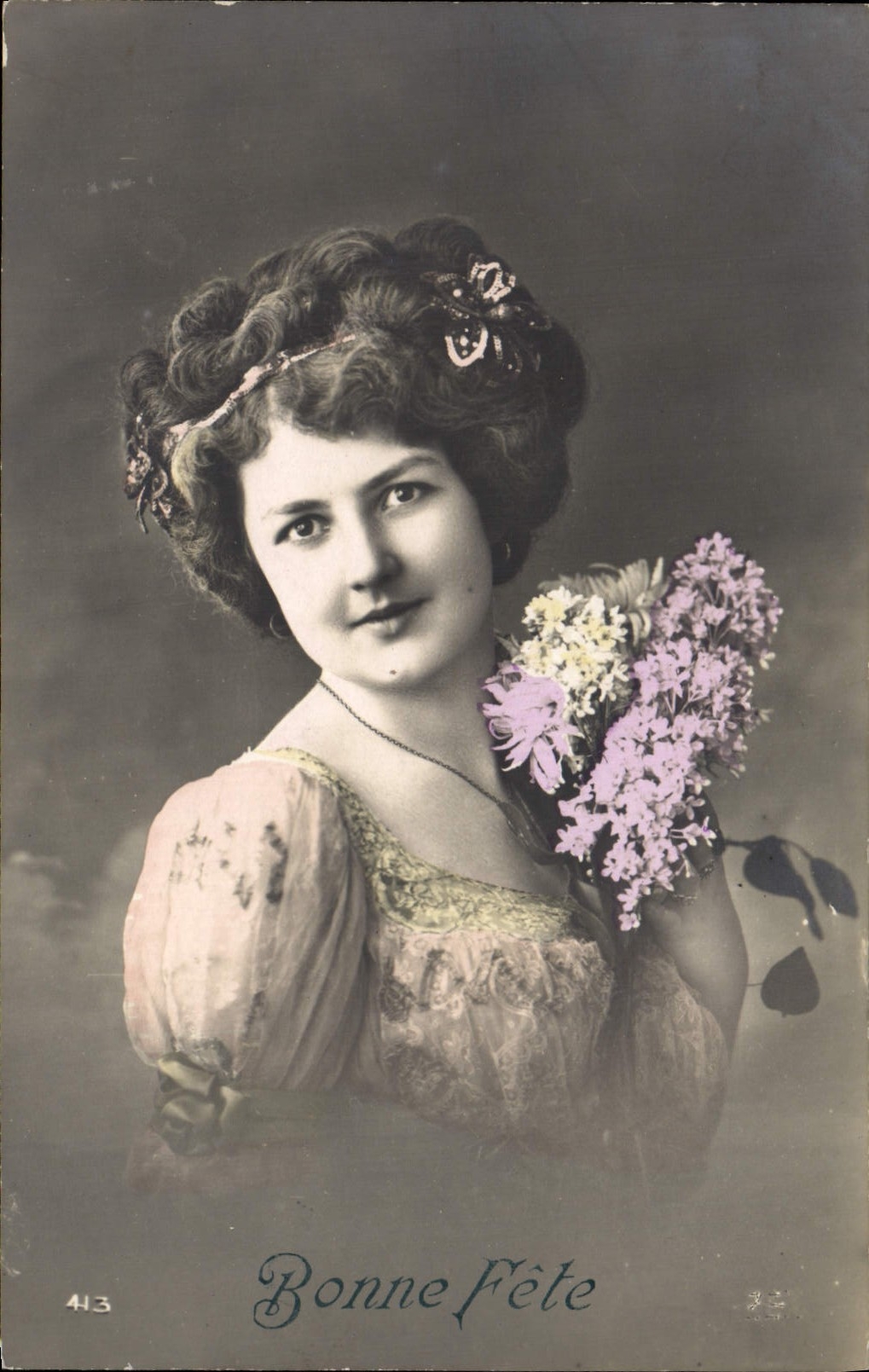 Jeune femme en robe à volants — tenant un bouquet de lilas — éditeur anonyme, n° 413