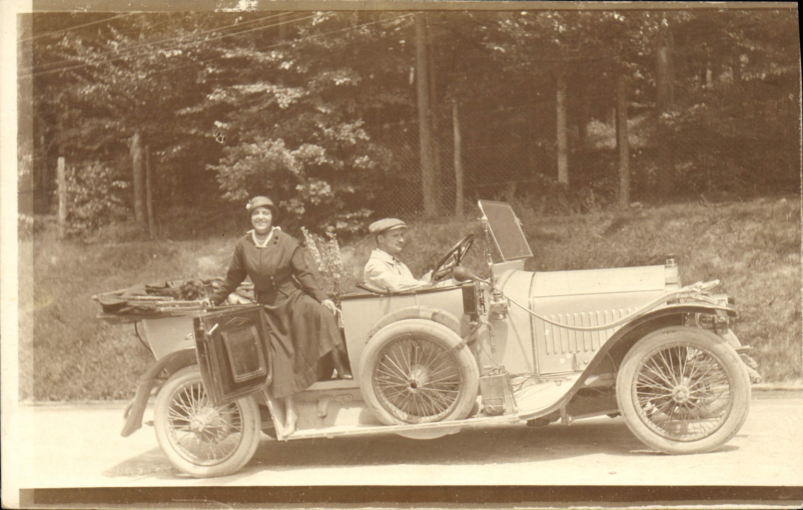Deux personnes dans une voiture ancienne — éditeur CPAPHIL, n° de série non visible
