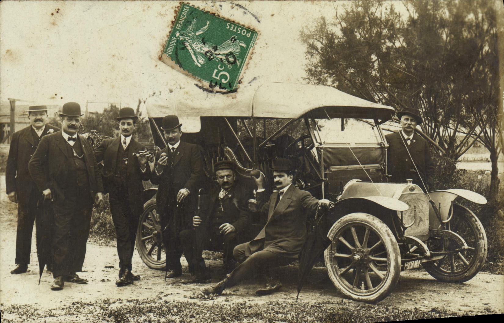 Grupo de hombres con automóvil antiguo — sello 5c verde — editor no visible