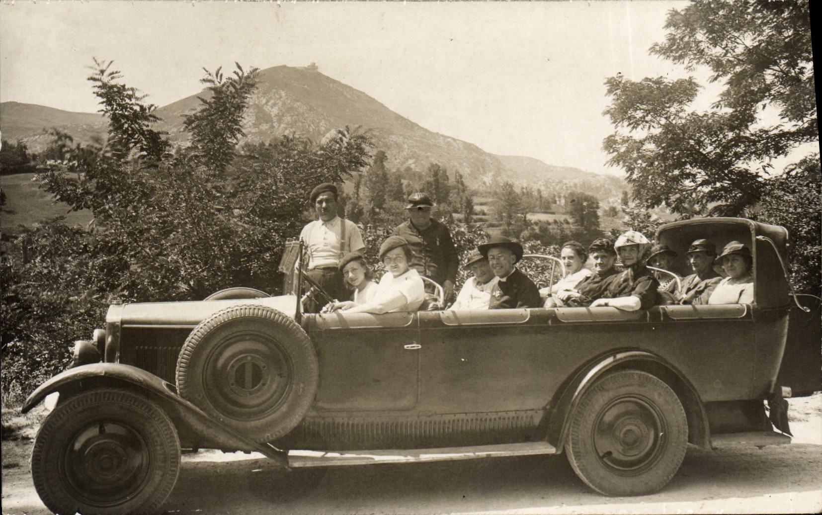 Groupe de personnes dans une voiture ouverte — montagne en arrière-plan — CPAPHIL
