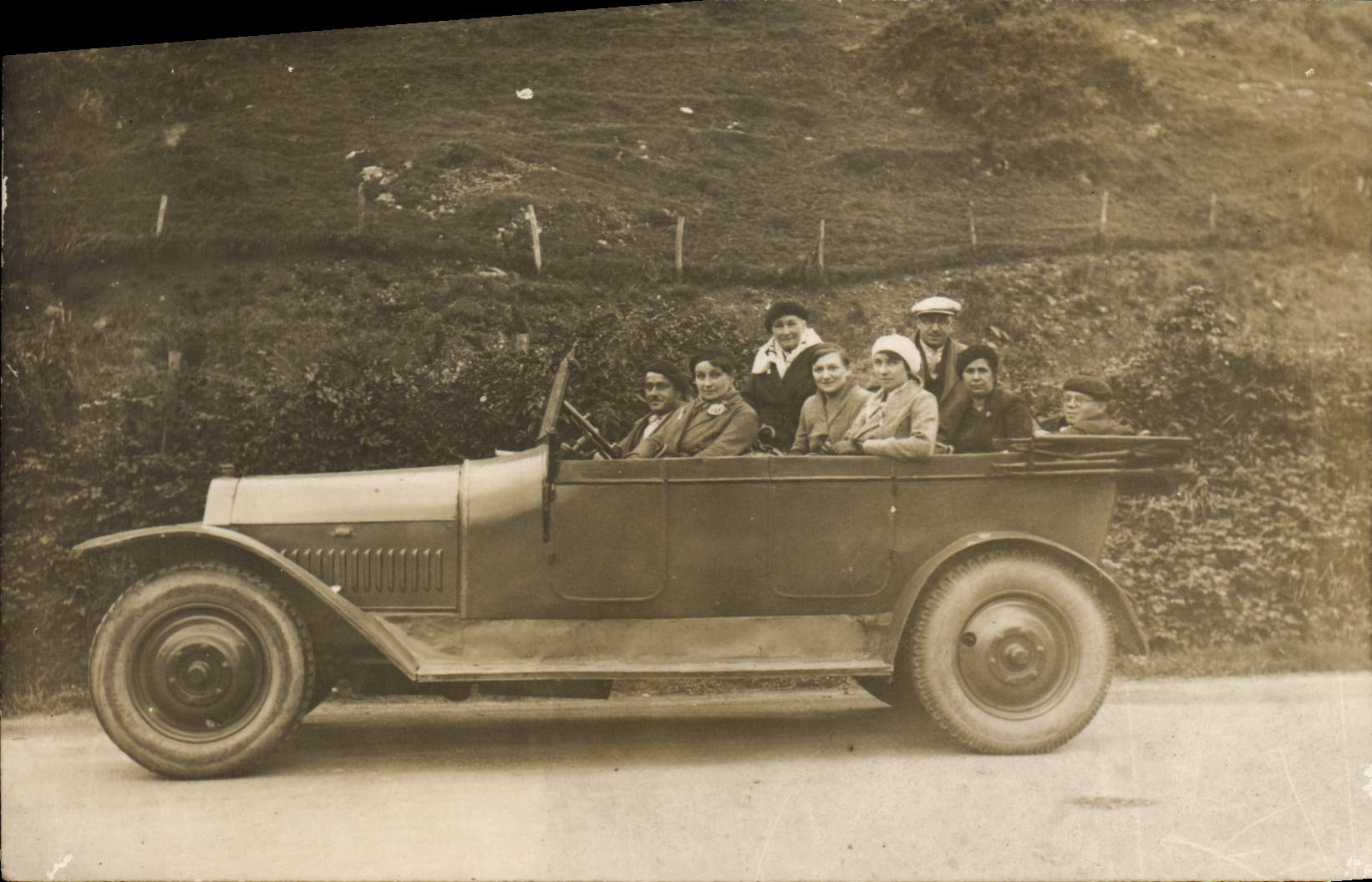 Groupe de personnes dans une voiture ouverte — Éditeur non identifiable, n° de série non visible