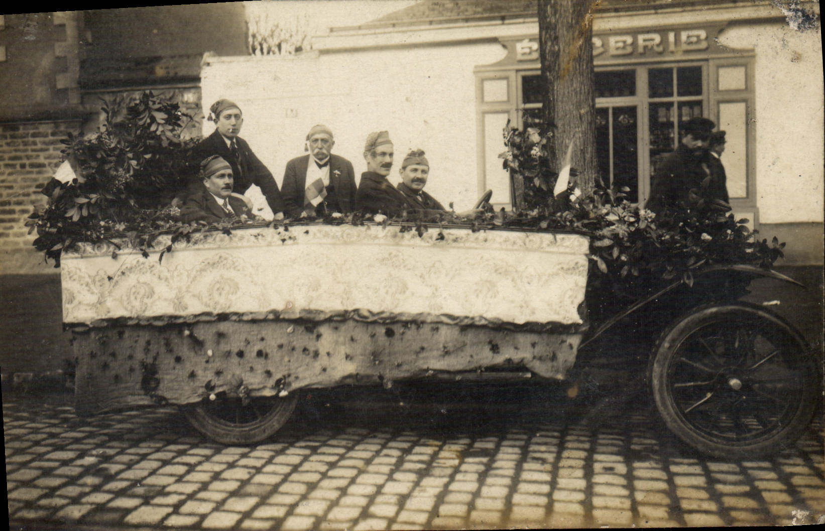 Célébration militaire — cortege funèbre décoré — devant une boulangerie
