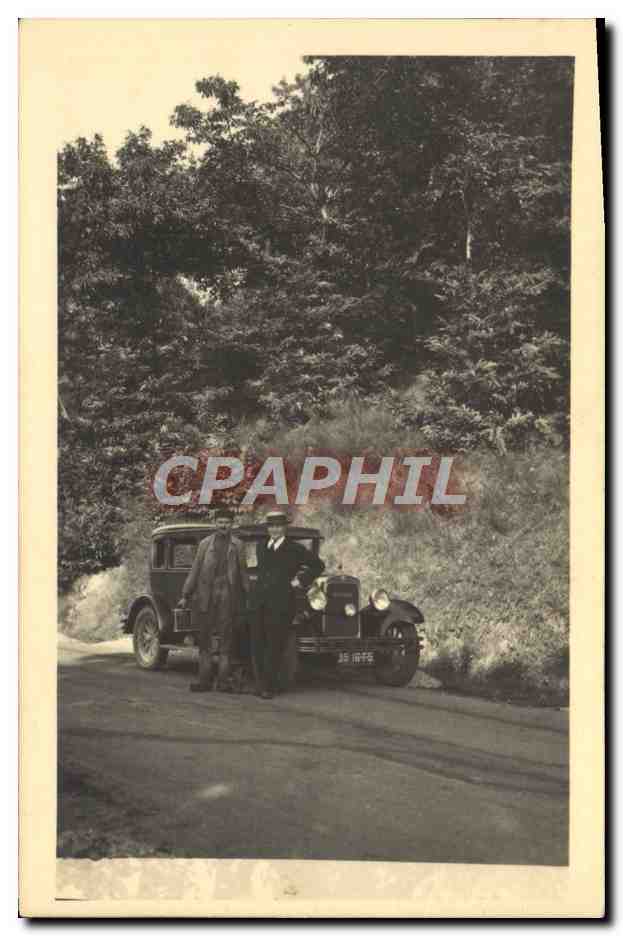 Deux hommes devant une voiture ancienne — route forestière — éditeur non visible