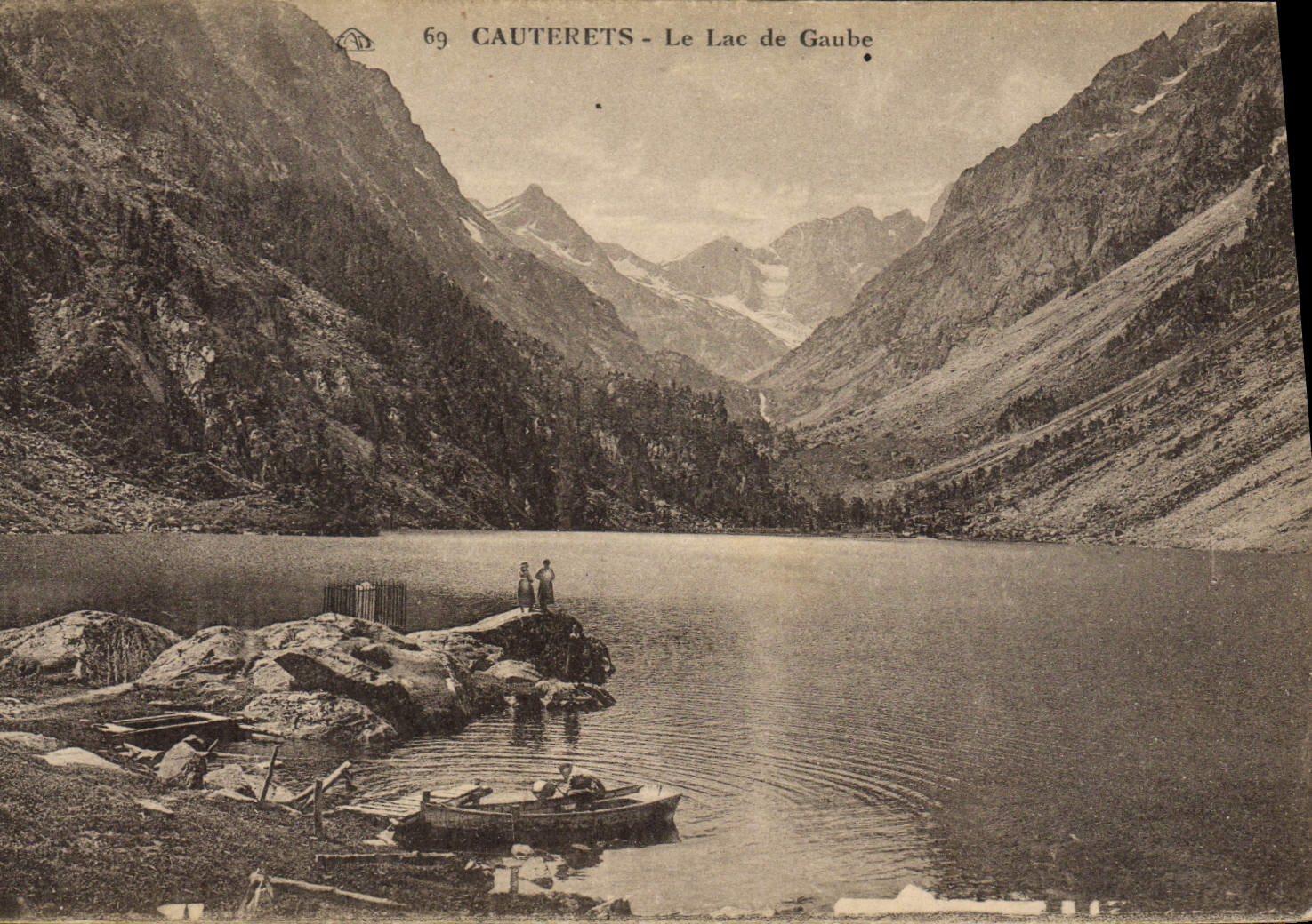 Cauterets - Le Lac de Gaube — vue du lac entouré de montagnes, avec deux personnes sur un rocher et une barque à l'avant-plan — éditeur CPAPHIL, n° 69