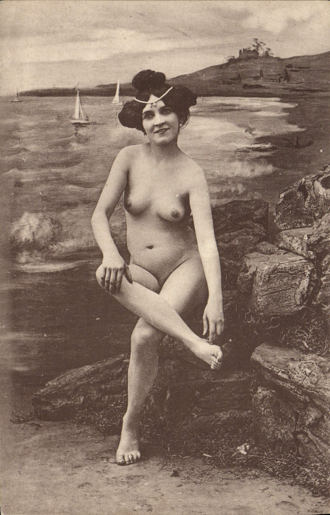 Nue assise sur des rochers — paysage marin avec voiliers — éditeur CPAPHIL, n° 330-10