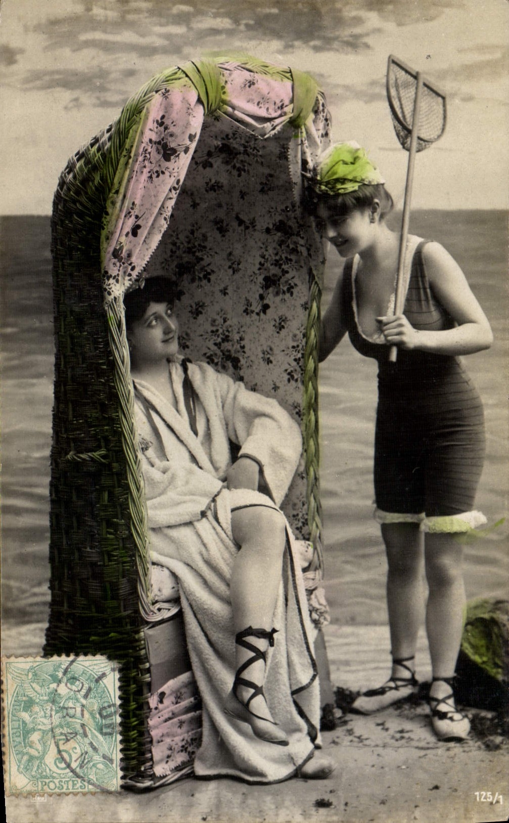 Twee vrouwen aan de strand — één zittend op een ligstoel, de ander staand met een net — uitgever 'Postes' n°125/1