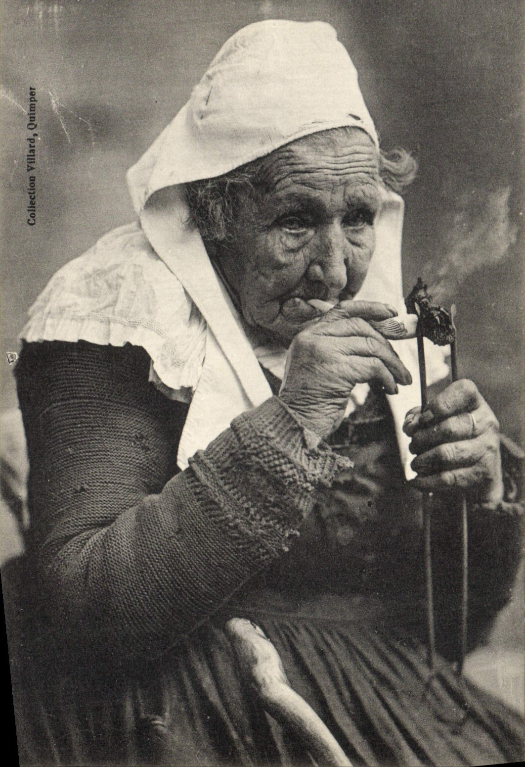 CPA Folklore Tabac Vieille fumeuse de Bretagne allumant sa pipe