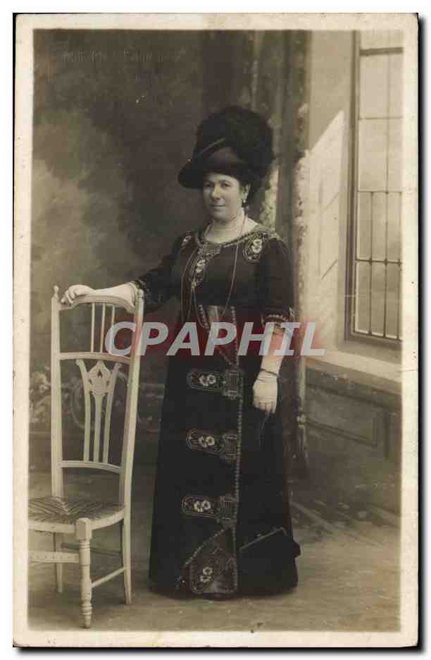 Femme en robe noire ornée — pose devant une chaise — éditeur inconnu, n° de série non visible