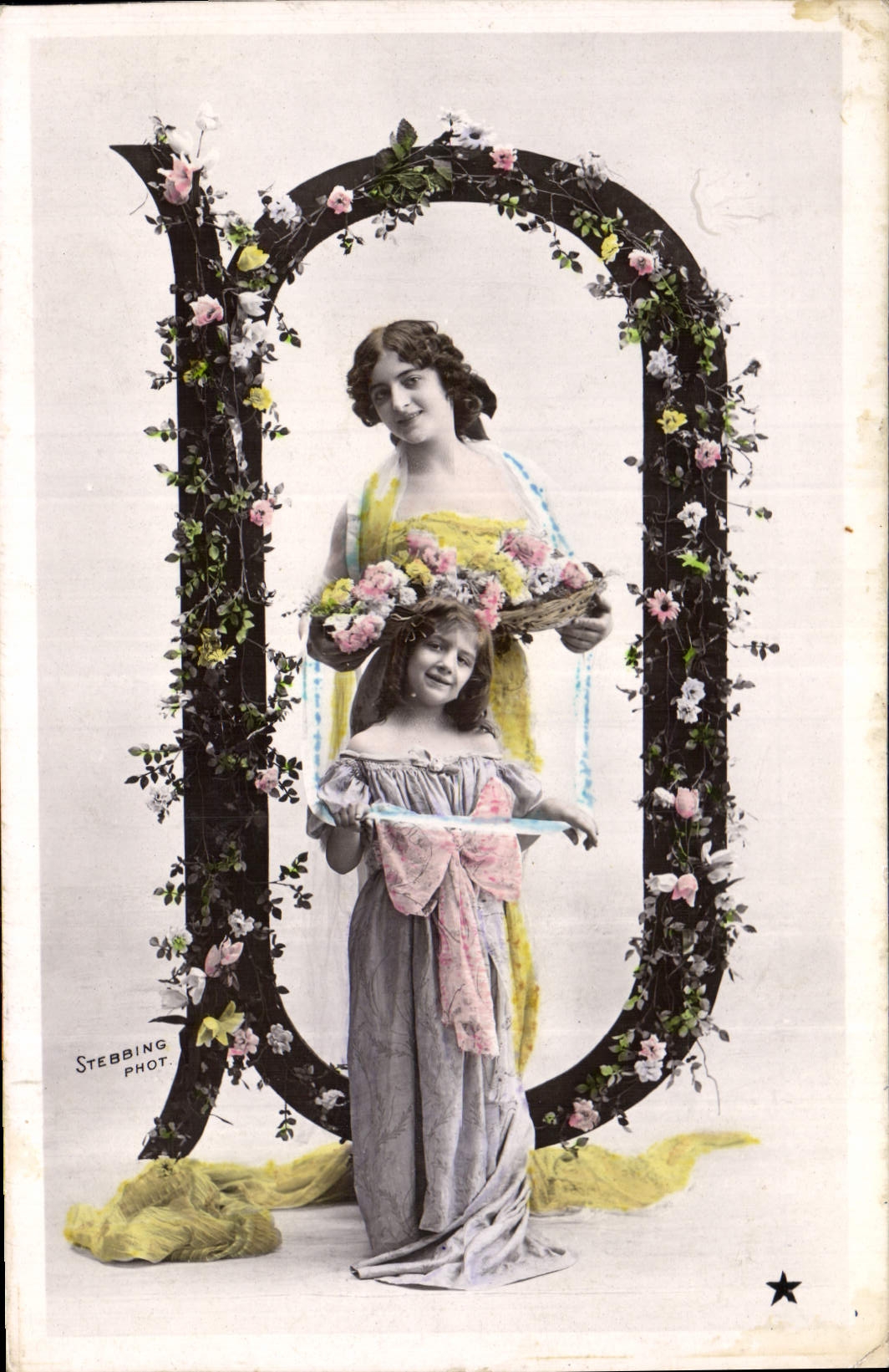 Deux jeunes filles dans une grande lettre ornée de fleurs — Stebbing Phot.