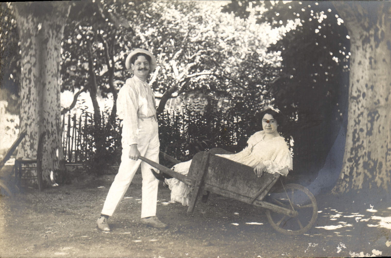 Jeune couple en jardin — homme poussant une brouette avec femme à l'intérieur — éditeur R. Desmoulins, 48, Rue Sénac, Marseille