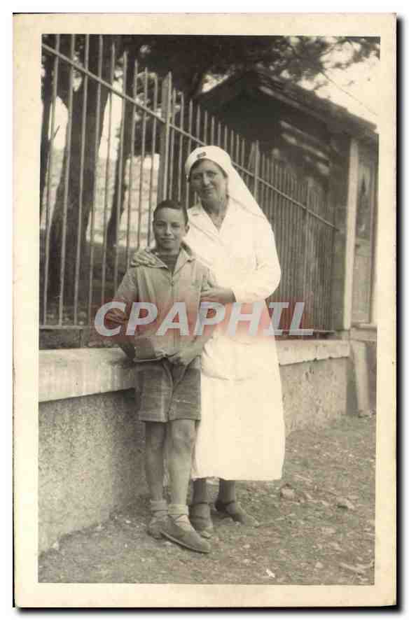 Infirmière et jeune garçon — devant une clôture — carte postale non datée