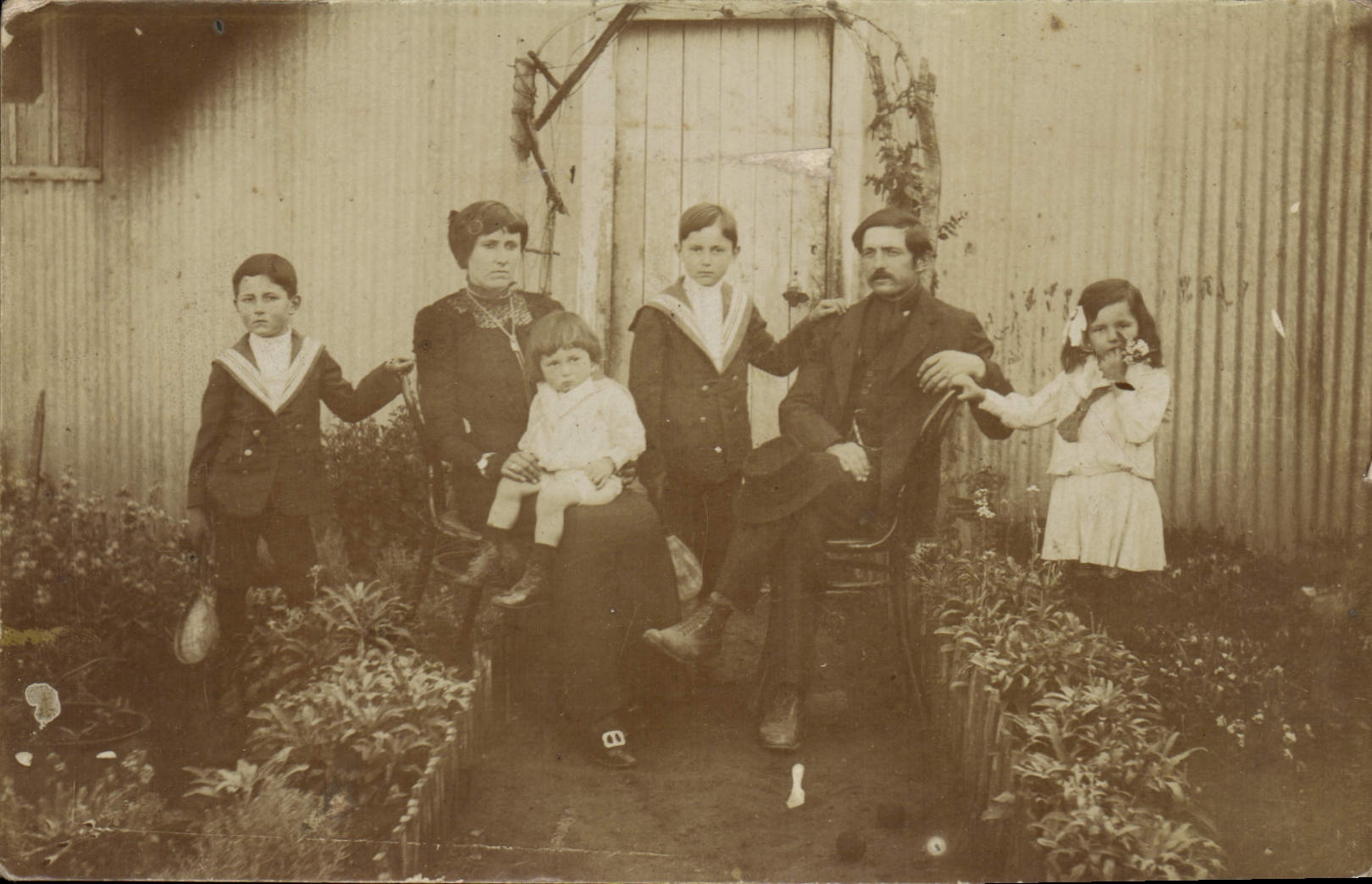 Famille devant une clôture en tôle ondulée — République Argentine