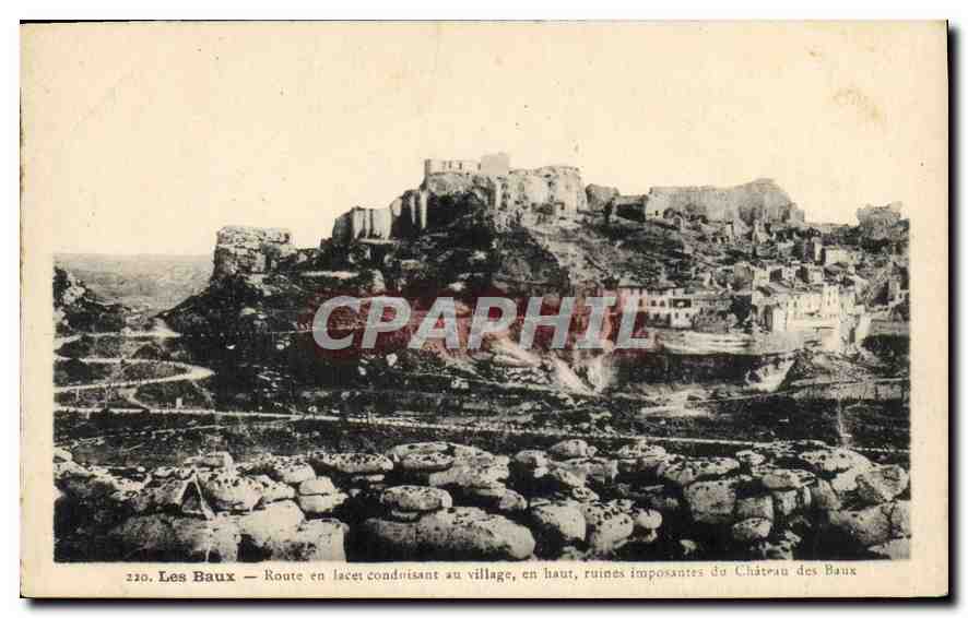 Les Baux — Route en lacet conduisant au village, en haut, ruines imposantes du Château des Baux — J. George
