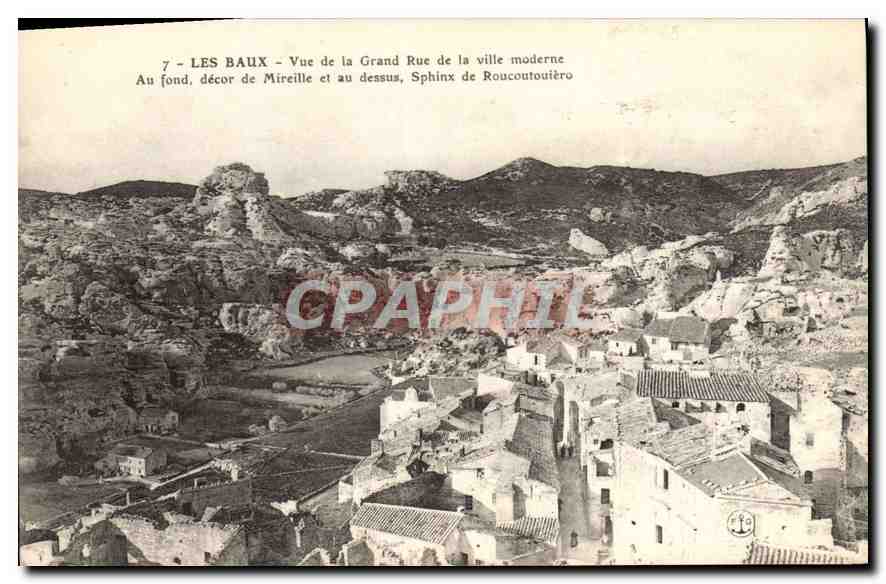 CPA Les Baux Vue de la Grand Rue de la ville moderne au fond decor de Mireille et au dessus Sphinx d