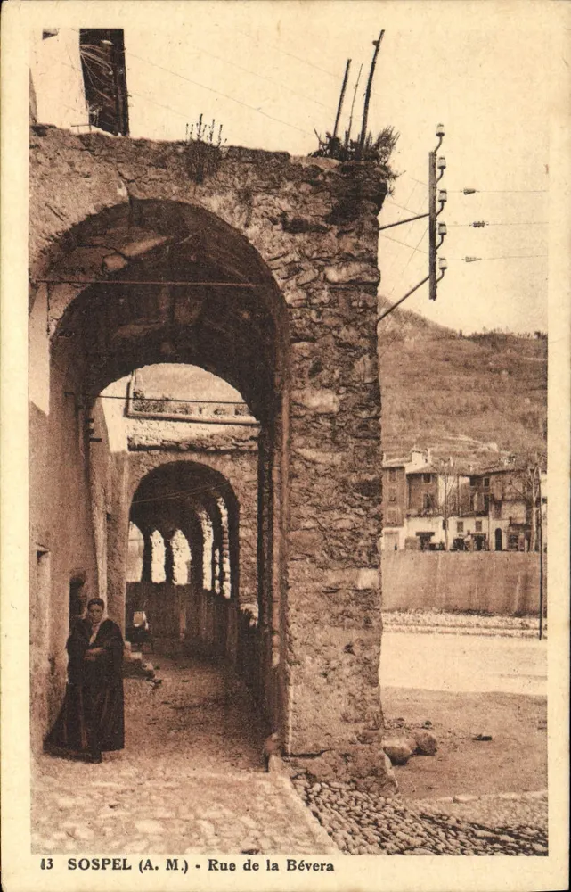 Sospel (A.M.) - Rue de la Bévera — arcadas em pedra, mulher com vestido escuro — editor A.M. n°13 - Frente