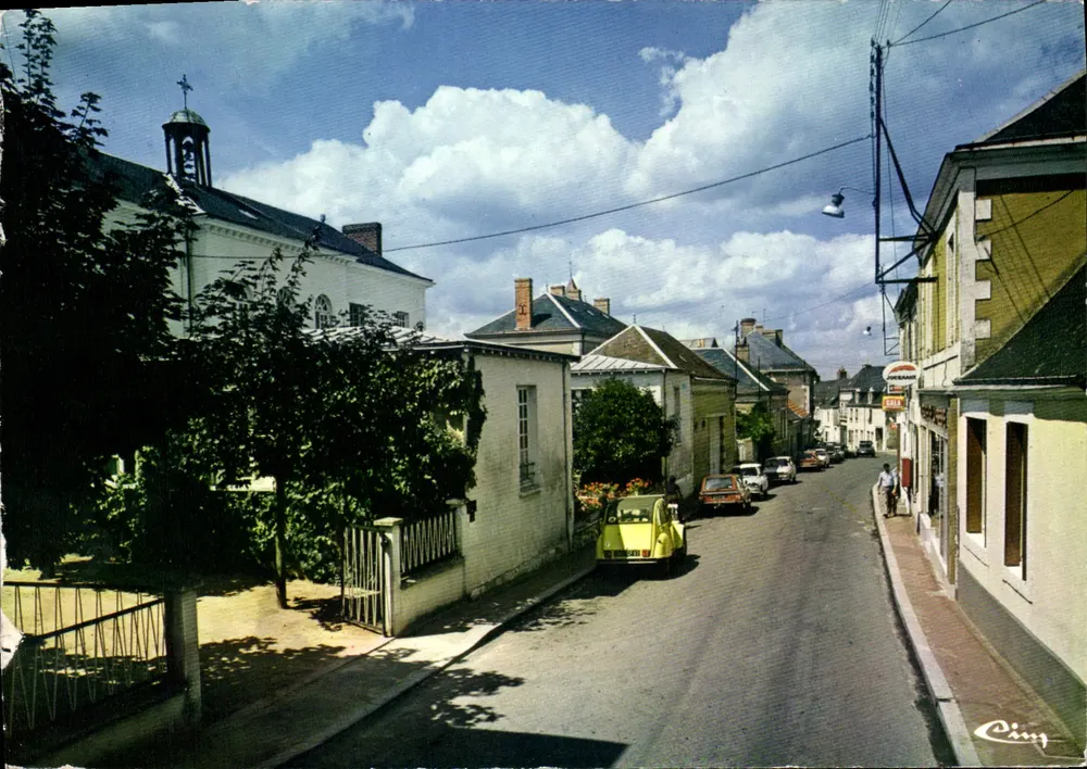 Mansigne (Sarthe) — rua principal com igreja e carro amarelo — Cinq - Frente