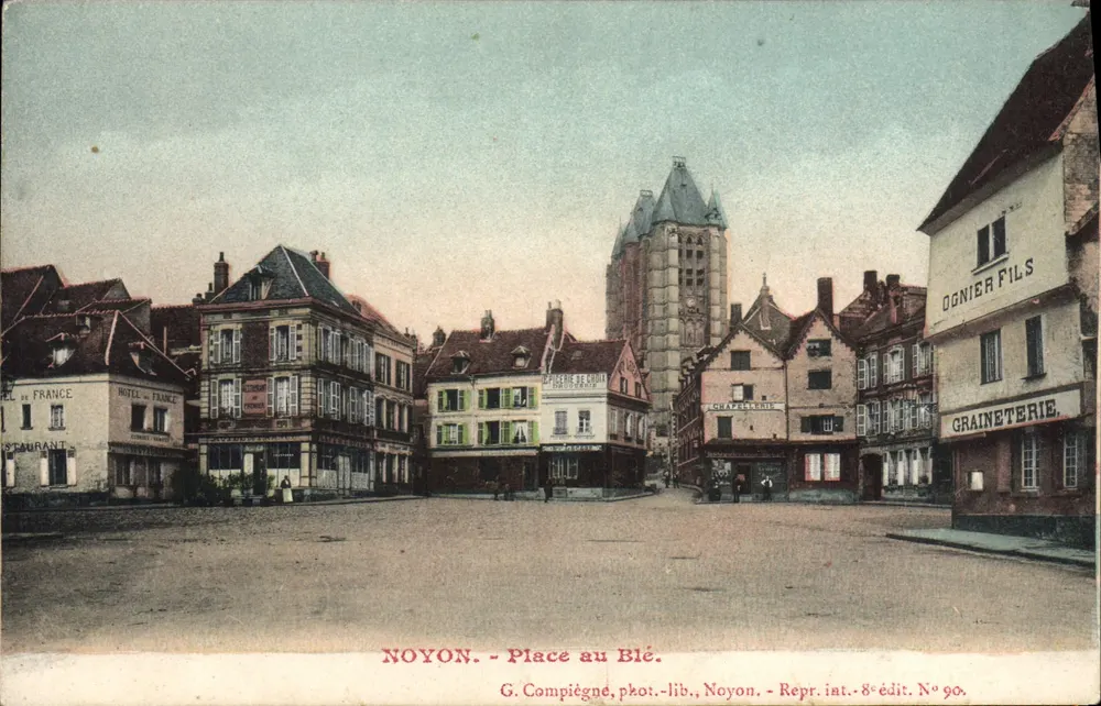 NOYON - Place au Blé — vista da praça com a torre da igreja e comércios — G. Compiègne, fotolib., Noyon. Repr. int. 8e édit. N° 90. - Frente
