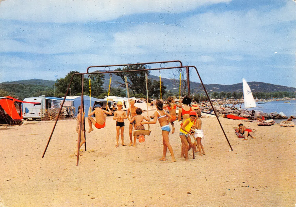 Camping Prairies de la Mer — scène de plage avec balançoires — Éditions Naturelles - Recto