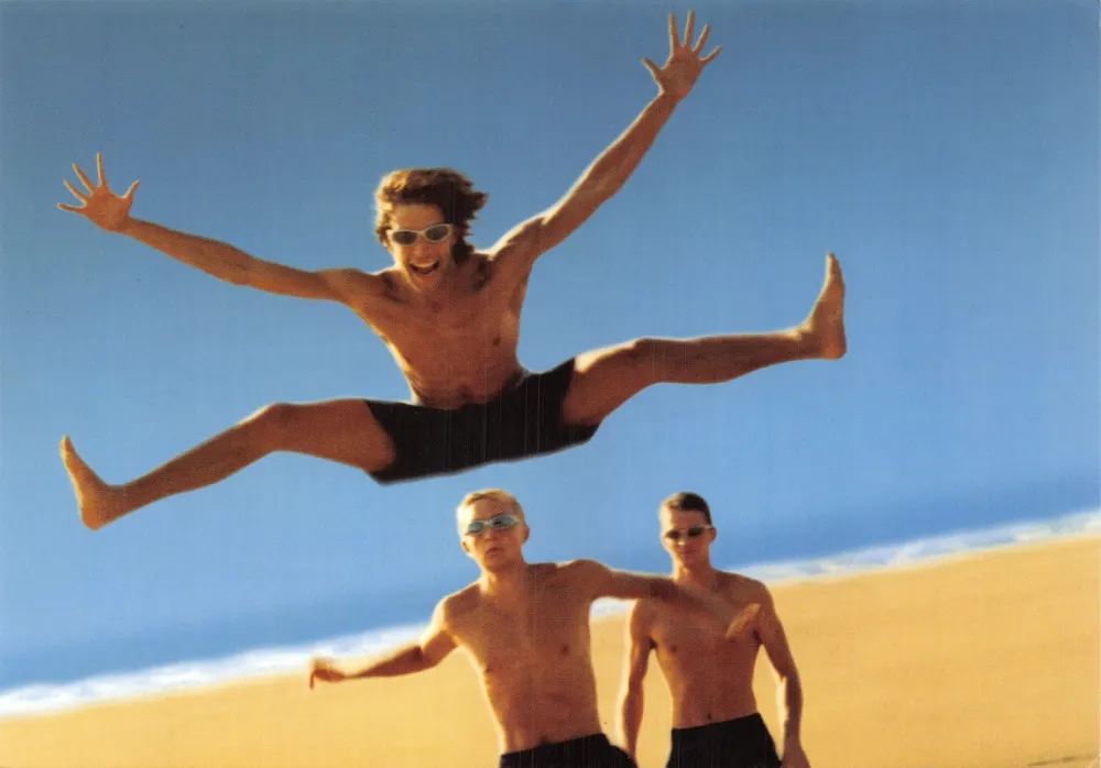 Junge Männer, die auf einem Strand springen — Strand-Szene — Verlag MOZAIC - Vorderseite