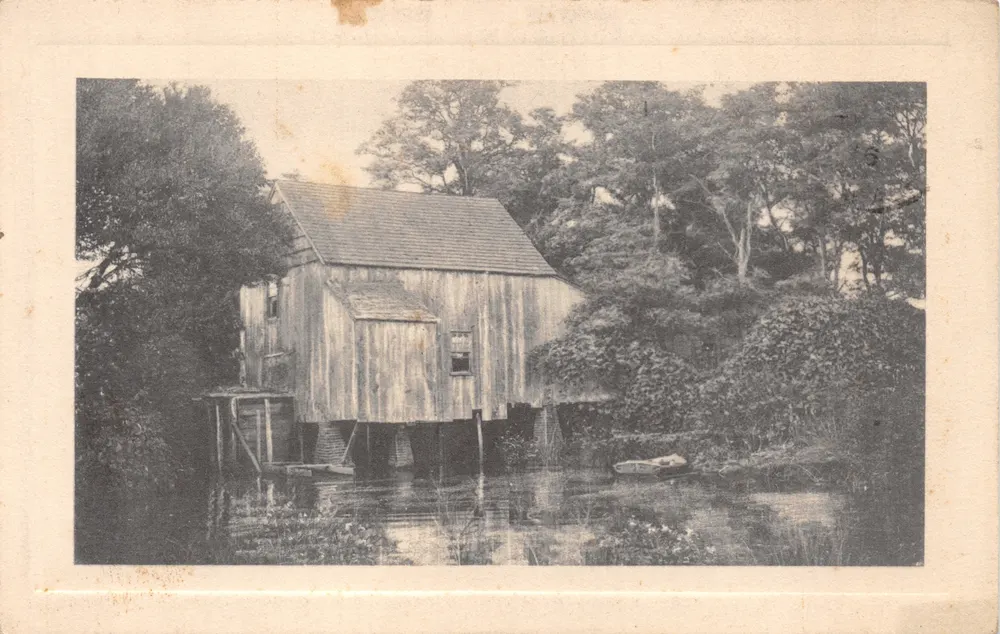 Wassermühle — Holzbau auf Pfählen am Rand eines Teichs — Verleger nicht sichtbar - Vorderseite