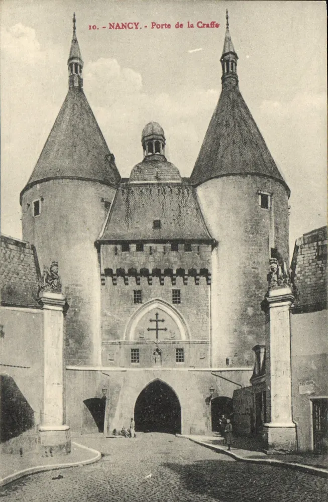 NANCY - Porta de la Craffe — vista da entrada monumental com duas torres cônicas e uma cruz acima do arco - Frente
