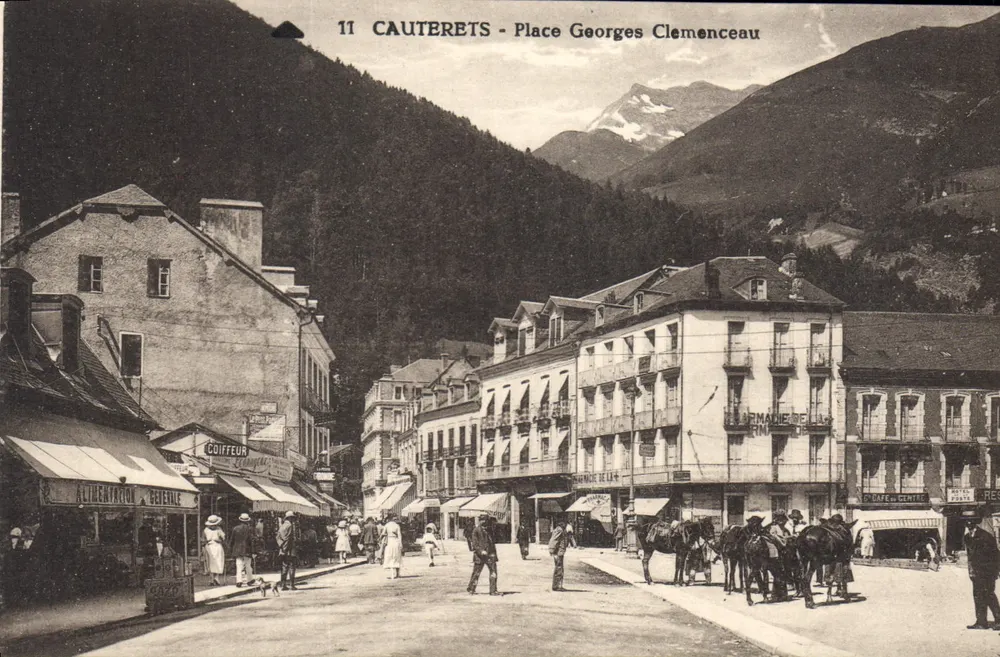 Cauterets - Praça Georges Clemenceau — vista da praça com comércios e montanhas em segundo plano - Frente