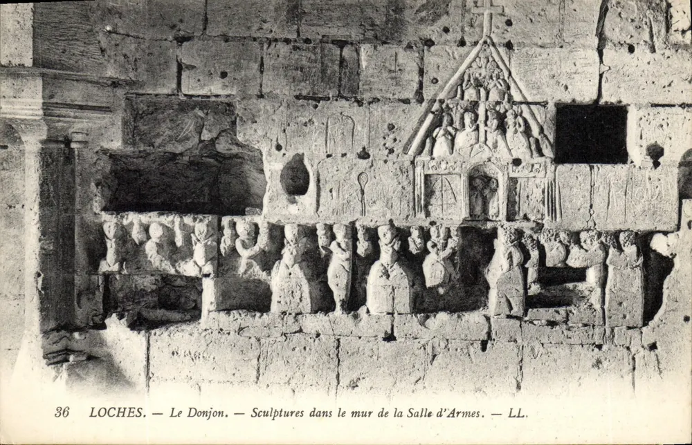 Loches — Der Bergfried — Skulpturen in der Wand des Waffenraums — LL. - Vorderseite