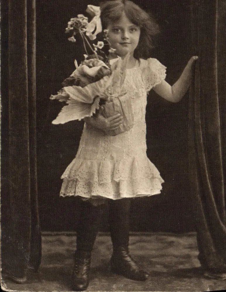 Menina pequena em vestido bordado — com buquê — foto de estúdio — Paris, 1918 - Frente
