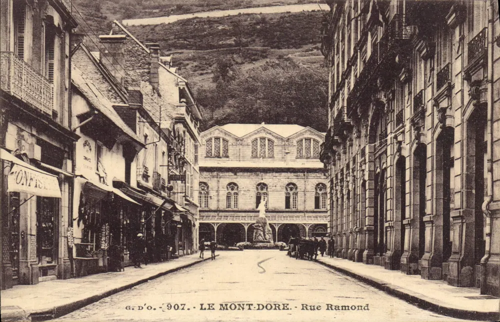 Le Mont-Dore - Rue Ramond — vista da praça com a estátua — G. D'O., n° 907 - Frente