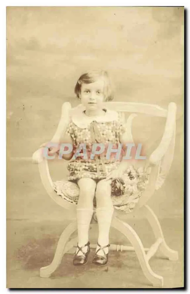 Menina sentada em uma cadeira de balanço — estúdio fotográfico — sem editor ou número visível - Frente