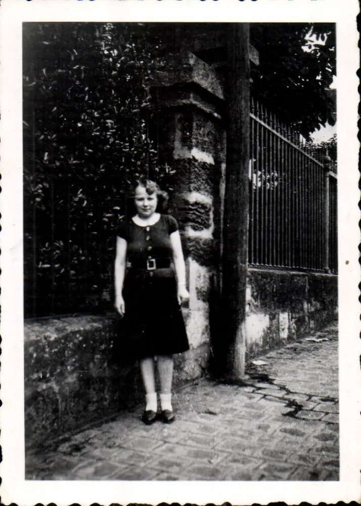 Vrouw in zwarte jurk — voor muur en hek — Storni L'Ammonite, 1946 - Voorkant