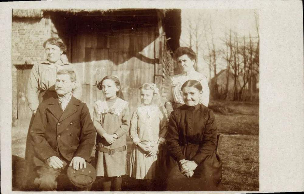 Familie voor een stal — antieke foto — geen uitgever of nummer zichtbaar - Voorkant