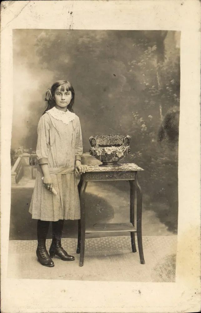 Menina diante de um vaso florido — estúdio - Frente