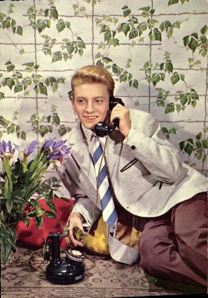 Jovem ao telefone — decoração de lianças — editor não visível - Frente