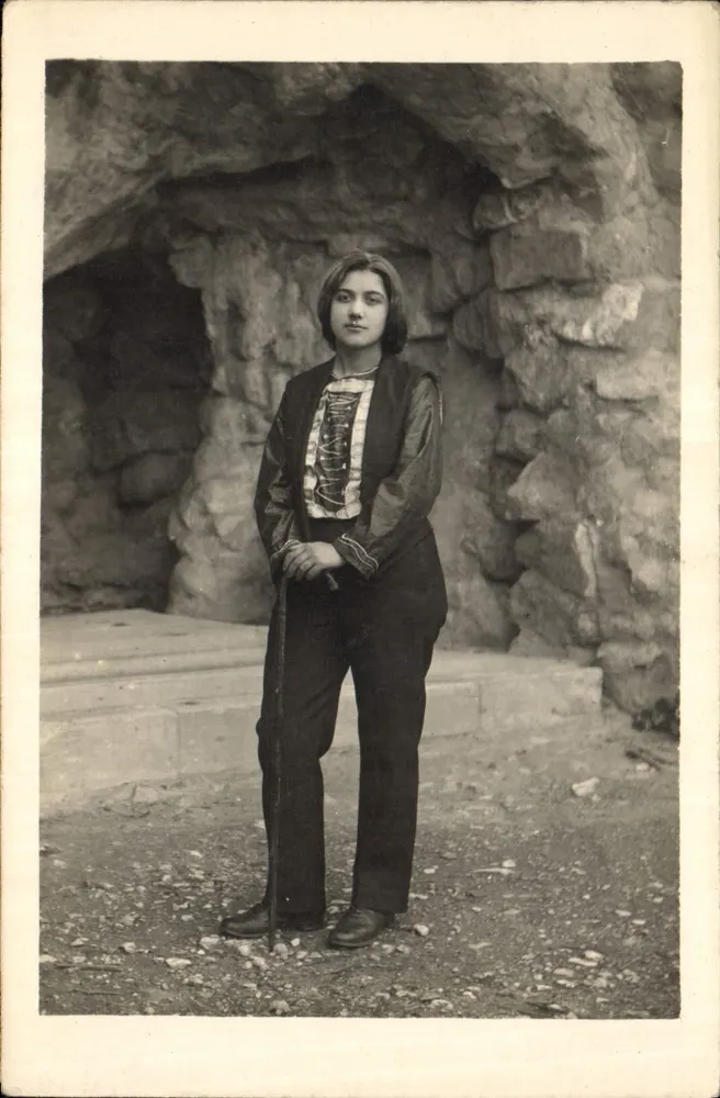 Jovem mulher em traje tradicional — diante de uma gruta — Carte postale italiana - Frente