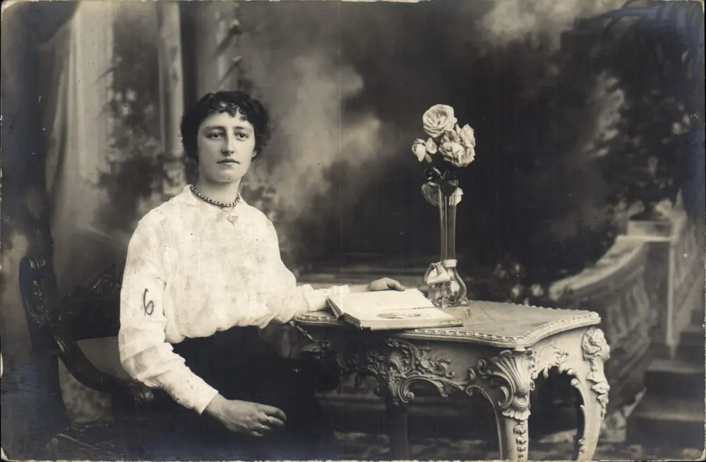 Jovem mulher sentada a uma mesa decorada — estúdio fotográfico — n°6 visível - Frente